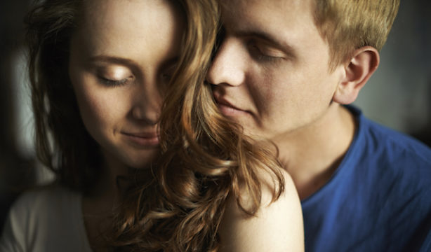 Young man enjoying smell of hair of his sweetheart
